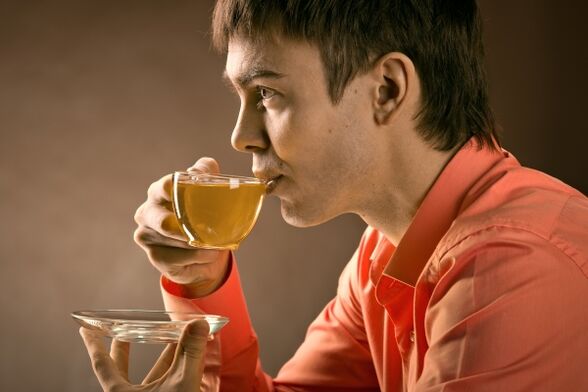 Un home bebe té de herbas para tratar a prostatite